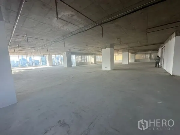 Office Space for rent in Watthana, Bangkok - Open-plan office with multiple columns and wraparound windows offering city views.