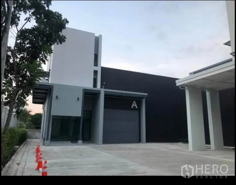 办公空间 出租在Wang Thonglang, Bangkok - 办公园区外观，A栋卷闸门、宽敞车道与安全路锥。