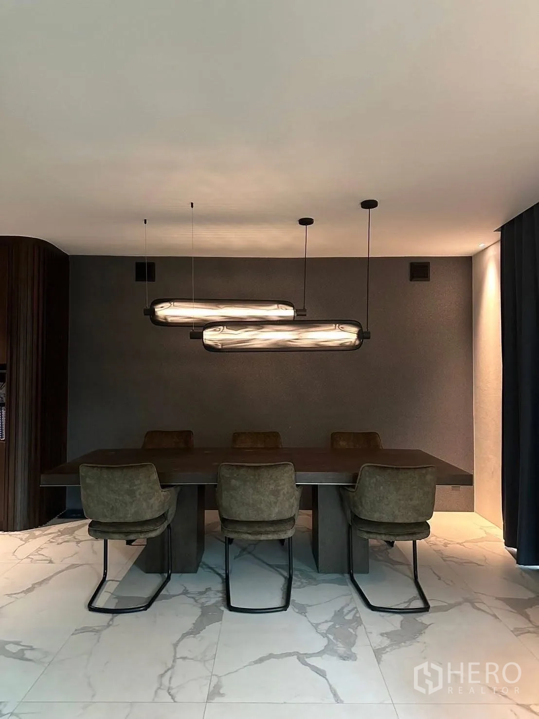 独立式住宅 出租在Lat Krabang, Bangkok - 餐厅，长木餐桌、六把餐椅与造型吊灯。