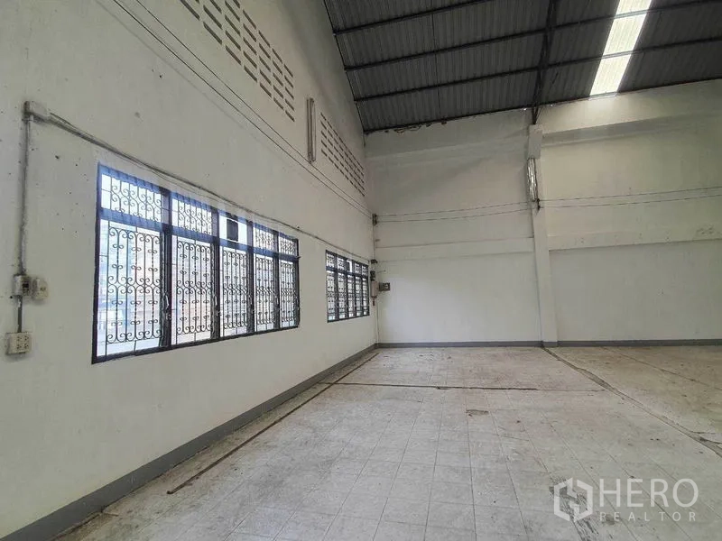 Warehouse for rent in Nakhon Pathom - Warehouse corner with tall windows, security grilles and high ceilings.