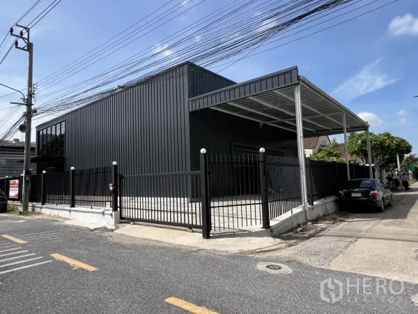 คลังสินค้า ให้เช่าในBang Na, Bangkok - ด้านหน้าตัวอาคารใหม่ ประตูรั้วเลื่อน หลังคากันสาด และทางเข้าจอดรถ