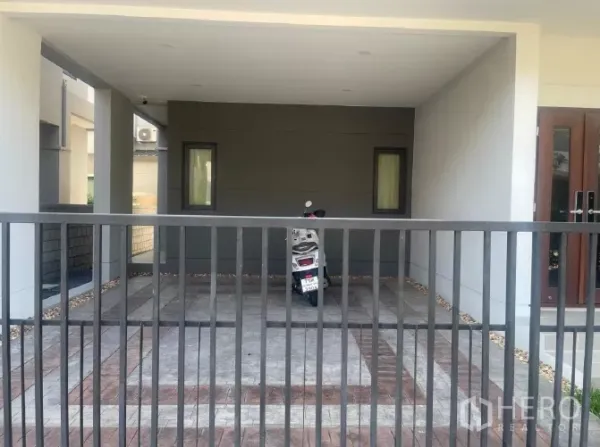 Detached House for rent or sale in Saphan Sung, Bangkok - Covered double carport with tiled driveway behind a metal gate.