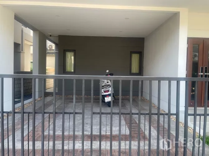 Detached House for rent or sale in Saphan Sung, Bangkok - Covered double carport with tiled driveway behind a metal gate.
