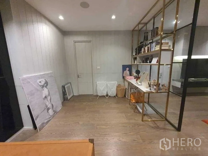 独立式住宅 出租或出售在Prawet, Bangkok - 多功能房，金色框架置物架与木地板。