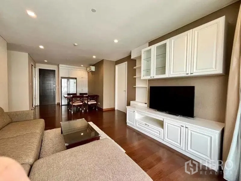 Condominium for rent in Watthana, Bangkok - Open-plan lounge and dining with TV wall unit and recessed lighting.