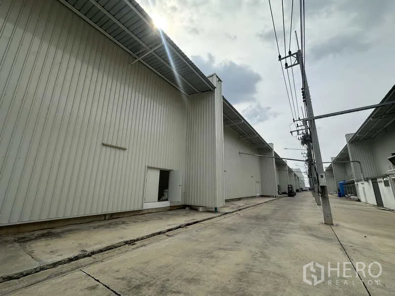 工厂 出租在Khlong Luang, Pathum Thani - 厂房后侧服务道路，长檐与电力杆设施