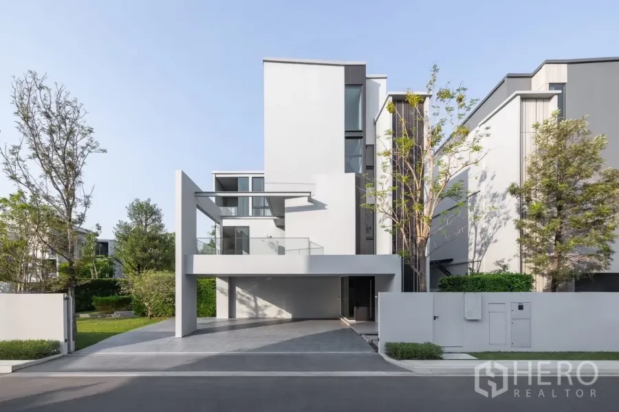 Detached House for rent in Saphan Sung, Bangkok - Modern three-storey detached house facade with carport and landscaped front yard.