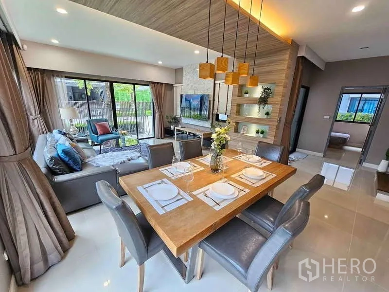 独立式住宅 出租在Prawet, Bangkok - 六人餐区，吊灯点缀，旁接花园推拉门