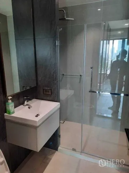 公寓 出租或出售在Phaya Thai, Bangkok - 现代浴室，玻璃淋浴房与壁挂式洗手台。