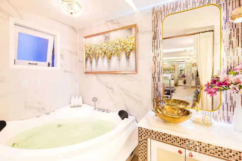 Townhouse for rent in Lat Phrao, Bangkok - Bathroom with corner jacuzzi tub, gold basin and mosaic backsplash.