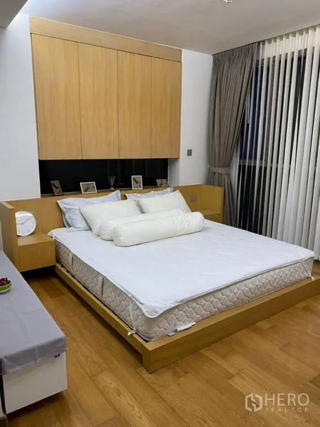 公寓 出租在Watthana, Bangkok - 卧室配木质平台床、收纳柜与落地窗帘