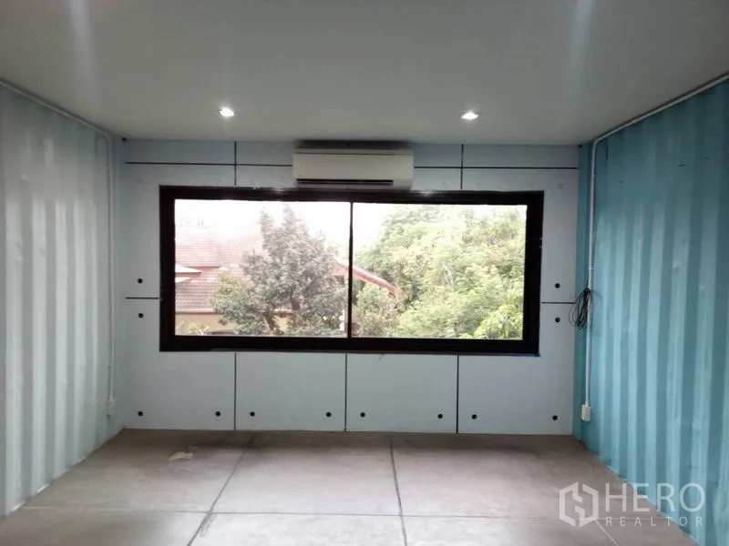 Retail Space for rent in Khlong Toei, Bangkok - Large window with split air conditioner overlooking greenery at the back of the unit.