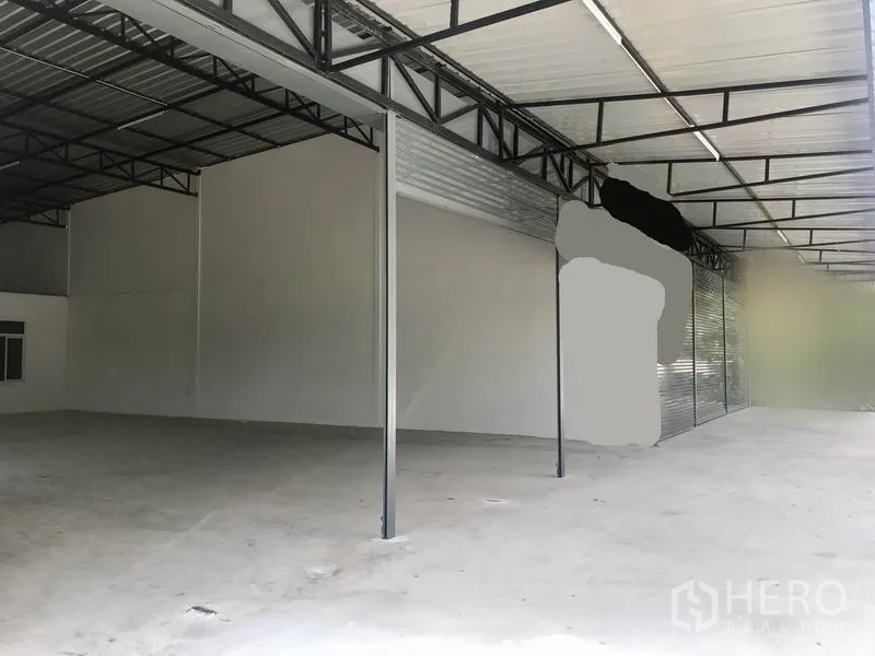 货栈 出租在Lam Luk Ka, Pathum Thani - 带顶装卸区，钢结构屋架，高挑屋顶与混凝土地面，配长卷帘门。