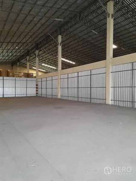 Warehouse for rent in Yan Nawa, Bangkok - Wide column-free area with corrugated metal side panels and exposed steel beams.