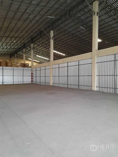 Warehouse for rent in Yan Nawa, Bangkok - Wide column-free area with corrugated metal side panels and exposed steel beams.