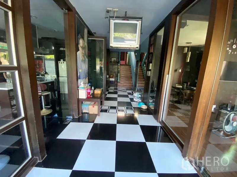 独立式住宅 出售在Suan Luang, Bangkok - 走廊，黑白棋盘地砖通向楼梯。