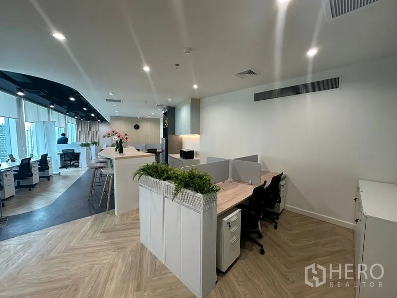 Office Space for rent - Cluster of cubicles with planters in a modern open office.