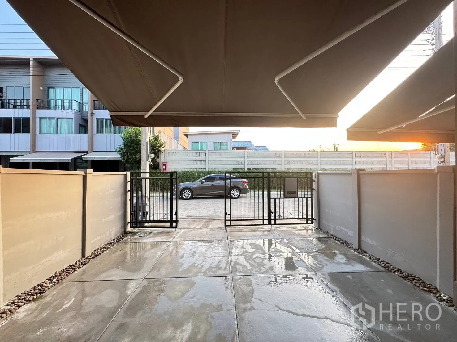 Townhouse for rent in Saphan Sung, Bangkok - Covered carport with awning and gated entrance at the front of the home.