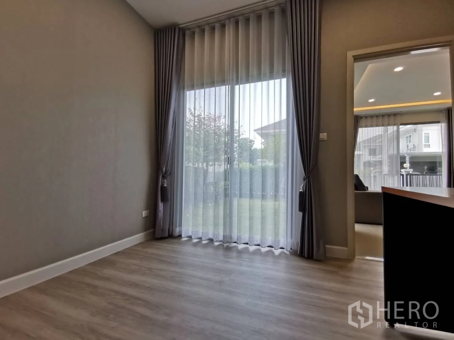 บ้านเดี่ยว for rent in Bang Phli, Samut Prakan - ห้องชั้นล่างเปิดสู่สวนด้วยประตูกระจกบานเลื่อน พร้อมผ้าม่านโปร่ง