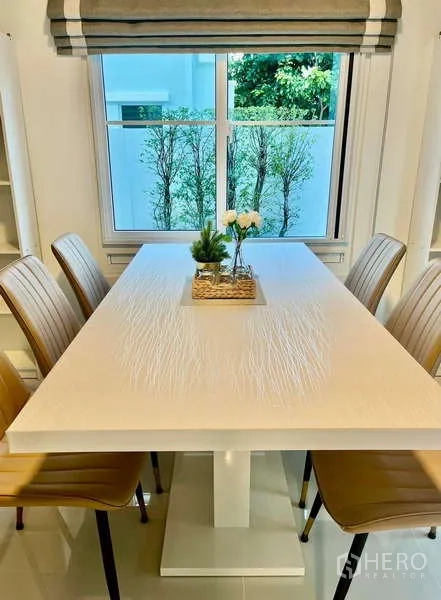 Detached House for rent in Bang Phli, Samut Prakan - Dining table for six by a window overlooking greenery.
