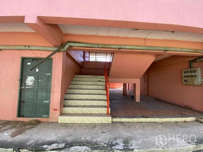 货栈 出租在Lat Lum Kaeo, Pathum Thani - 粉色附属楼的楼梯与服务区，铺瓷砖台阶和电箱。