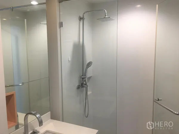 公寓 出租或出售在Watthana, Bangkok - 现代化浴室，玻璃淋浴间，顶喷花洒与简洁白色墙面。