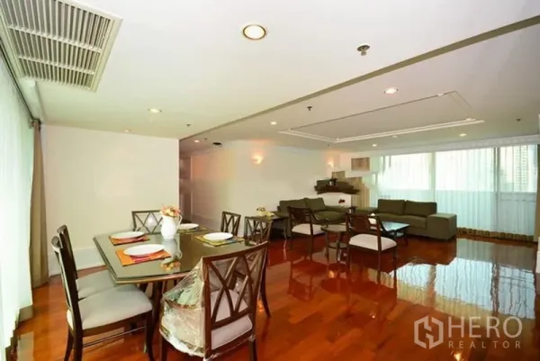 Apartment for rent in Khlong Toei, Bangkok - Open-plan dining and living space with multiple chairs, ceiling lights and wide windows bringing natural light.