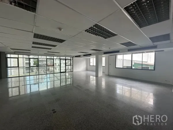 办公空间 出租 - 开放式办公楼层，宽幅窗户、城市景观、吊顶与抛光石材地面。