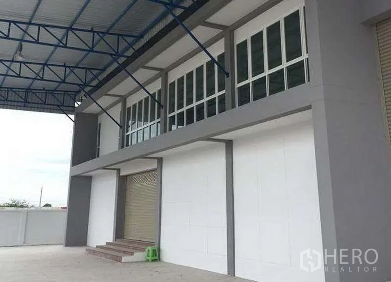Warehouse for rent in Bang Bo, Samut Prakan - Loading area with metal canopy, roller shutter doors and steps leading to the office block.