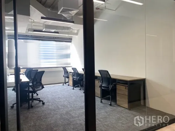 办公室 for rent in Bang Rak, Bangkok - 玻璃隔断办公间，成排工位、地毯地面与桌下抽屉柜。
