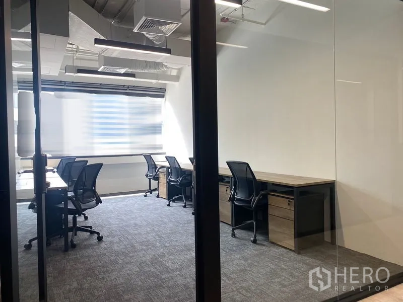办公室 for rent in Bang Rak, Bangkok - 玻璃隔断办公间，成排工位、地毯地面与桌下抽屉柜。