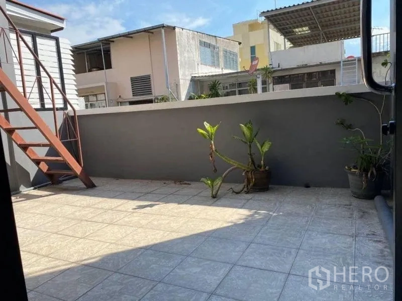 带办公室的家 出租在Bang Rak, Bangkok - 日照充足的瓷砖露台，摆放花盆，可见社区景观。