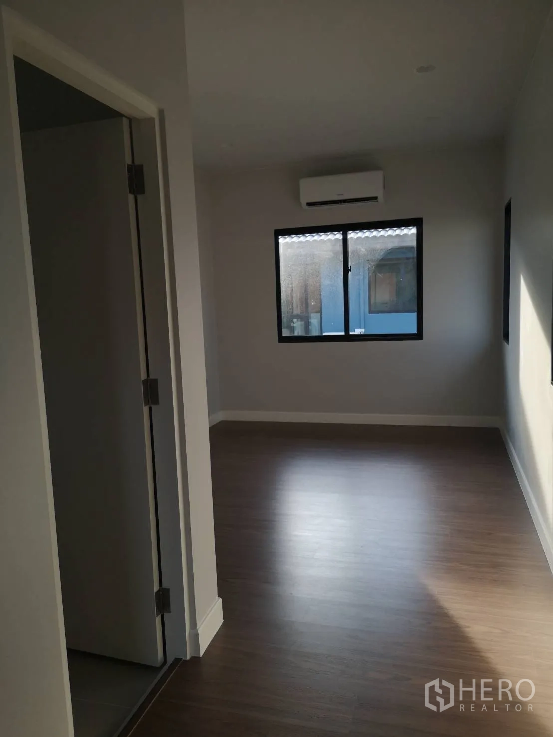 Detached House for sale in Lam Luk Ka, Pathum Thani - Cozy bedroom with a window and wall-mounted air conditioner.