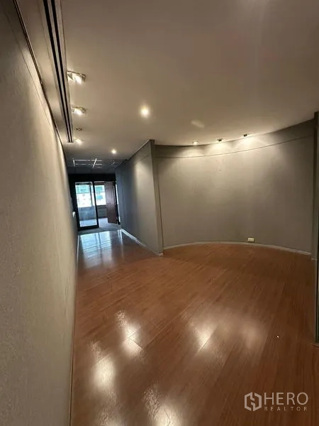 办公空间 出租在Watthana, Bangkok - 狭长展示式走廊，木地板与射灯，通向玻璃门