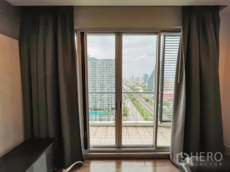 Condominium for sale - Sliding glass doors opening to a balcony with Bangkok skyline views.