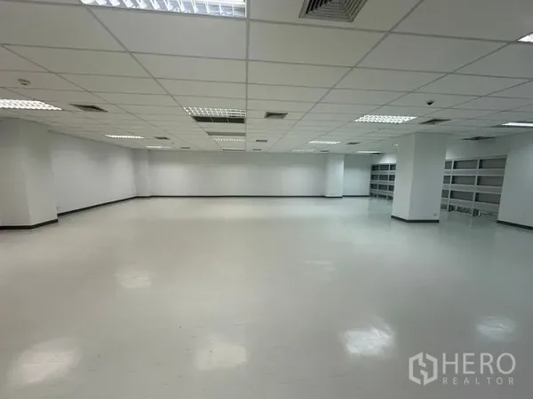 Office Space for rent in Bang Rak, Bangkok - Spacious office floor with minimal columns, white walls and a long run of built-in shelving along the back wall.