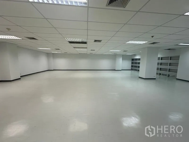 Office Space for rent in Bang Rak, Bangkok - Spacious office floor with minimal columns, white walls and a long run of built-in shelving along the back wall.