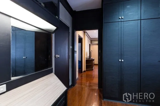 Detached House for rent in Watthana, Bangkok - Hallway with built-in wardrobes and dressing table in dark wood finish.