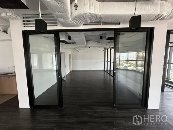 办公空间 出租 - 开放式办公室，深色地板，玻璃隔断门与外露风管天花。