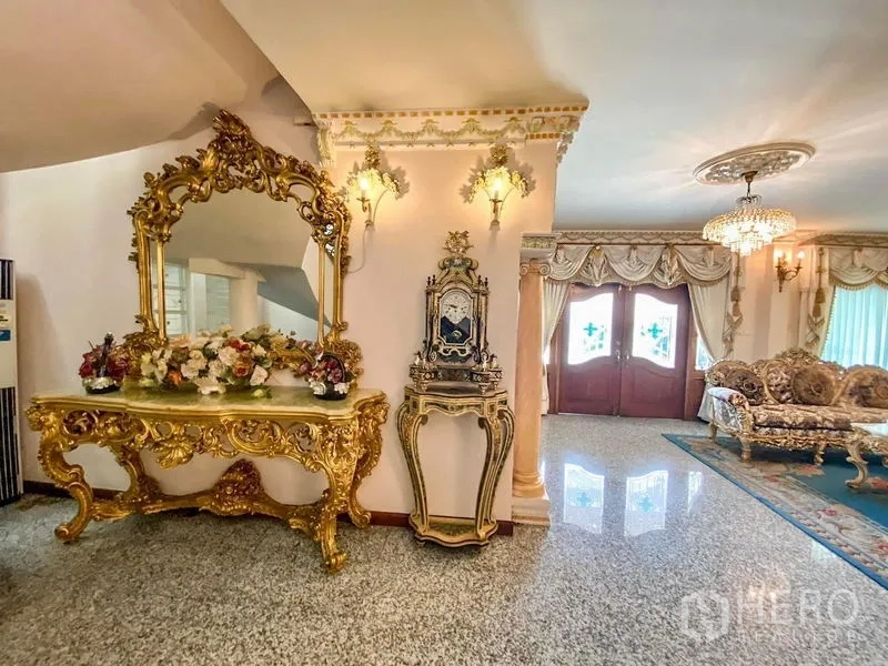 Detached House for rent or sale in Bang Khen, Bangkok - Foyer with gilded mirror console and vintage clock, opening toward the formal living room.