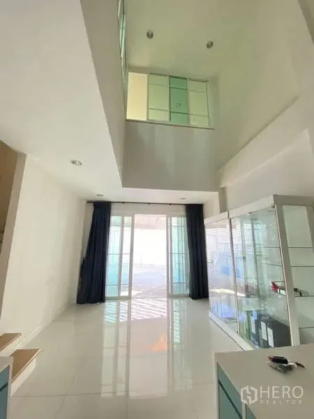 Home Office for rent or sale - Double-height living or reception area with glossy tile floors and tall sliding glass doors.