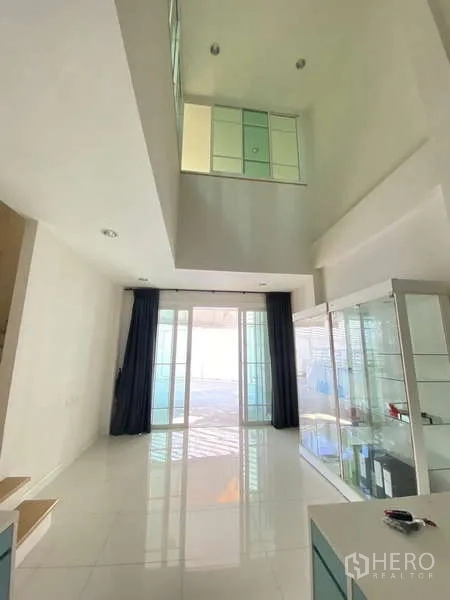 Home Office for rent or sale - Double-height living or reception area with glossy tile floors and tall sliding glass doors.