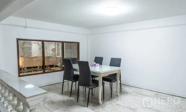 Townhouse for rent in Watthana, Bangkok - Bright dining nook with a table for four beside a decorative window.