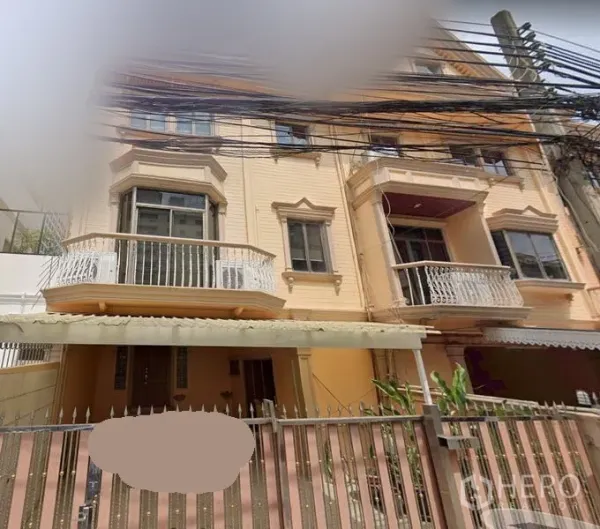 Townhouse for rent in Sathon, Bangkok - Three-storey townhouse exterior in Sathon with curved balconies, gated entry and covered carport near BTS Chong Nonsi.