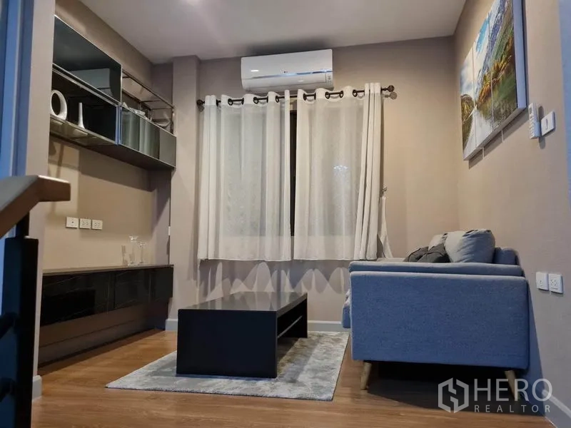 Detached House for rent or sale in Saphan Sung, Bangkok - Upstairs family corner with sofa, wall storage and air conditioning.