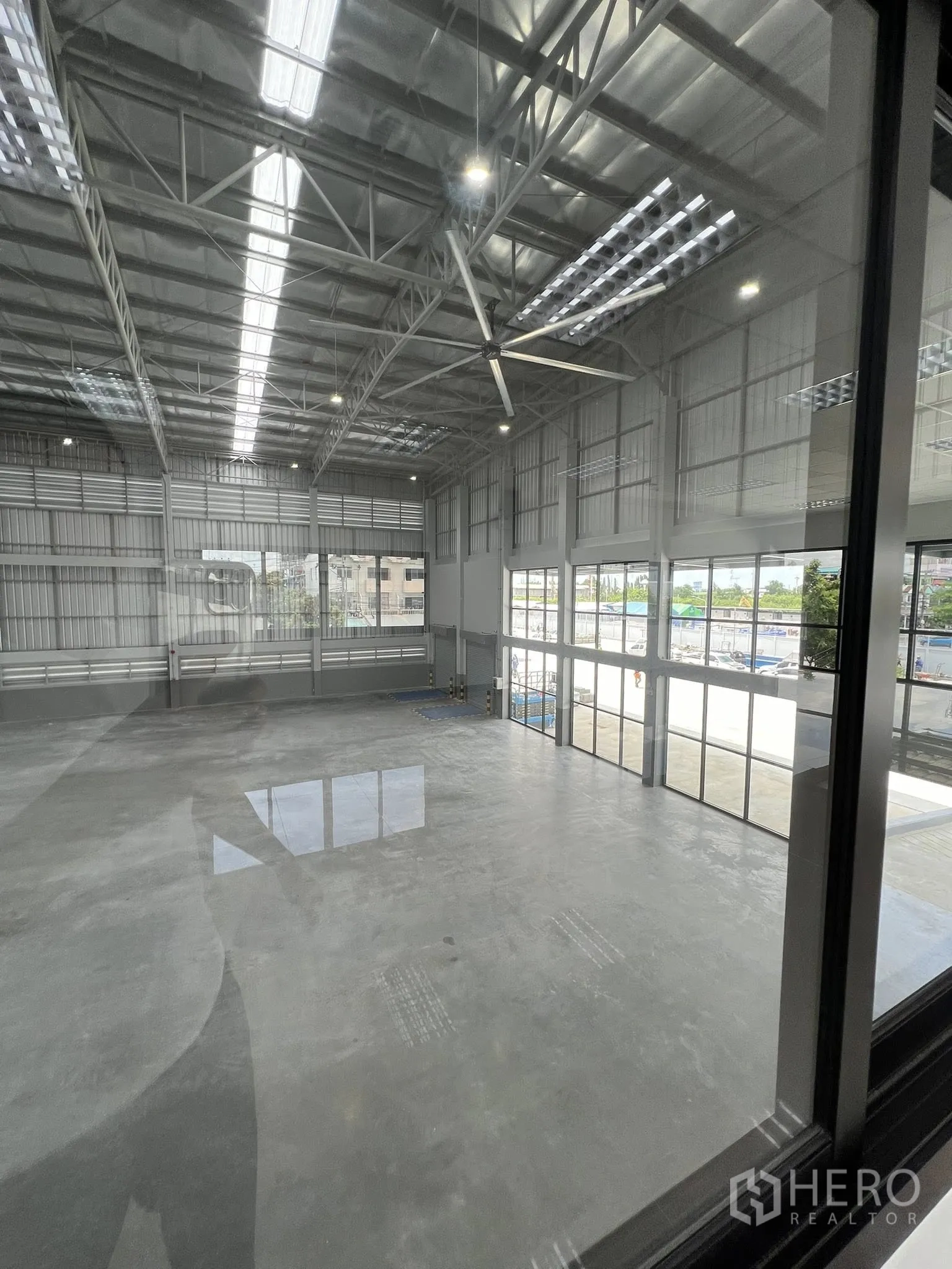 โกดัง for rent in Phra Pradaeng, Samut Prakan - มุมมองจากสำนักงานลงสู่พื้นโกดัง เห็นโครงหลังคาและผนังกระจกด้านหน้า