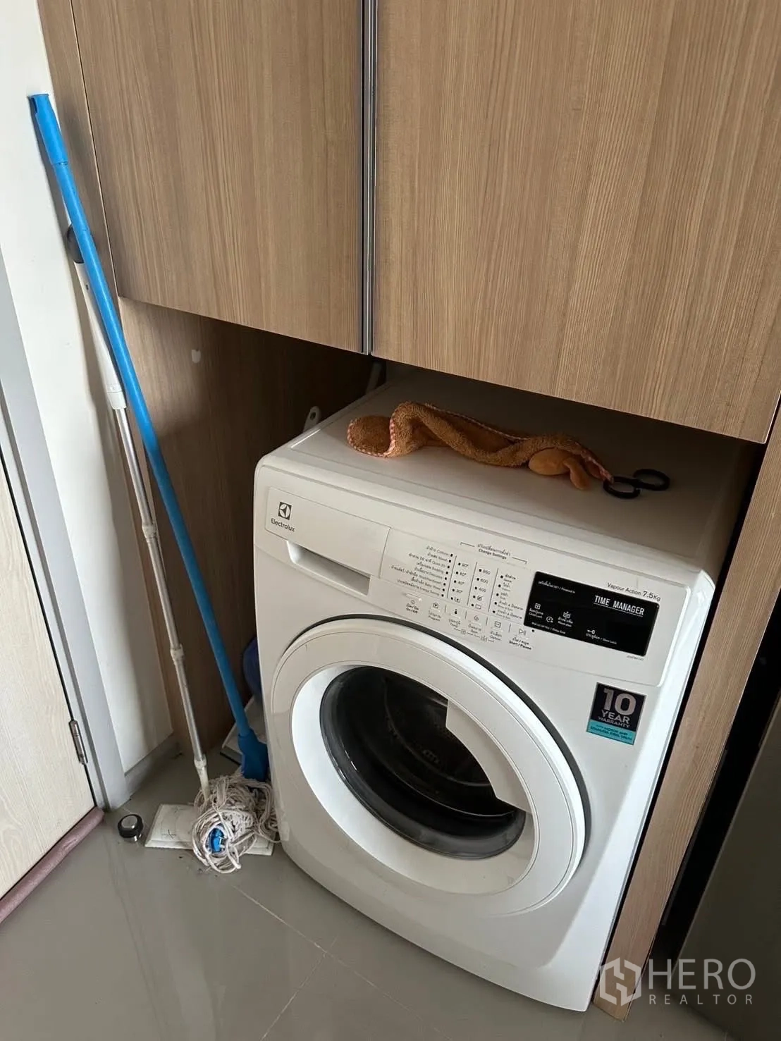 公寓 出租在Chatuchak, Bangkok - 室内前置式洗衣机，嵌入木质柜体下方。