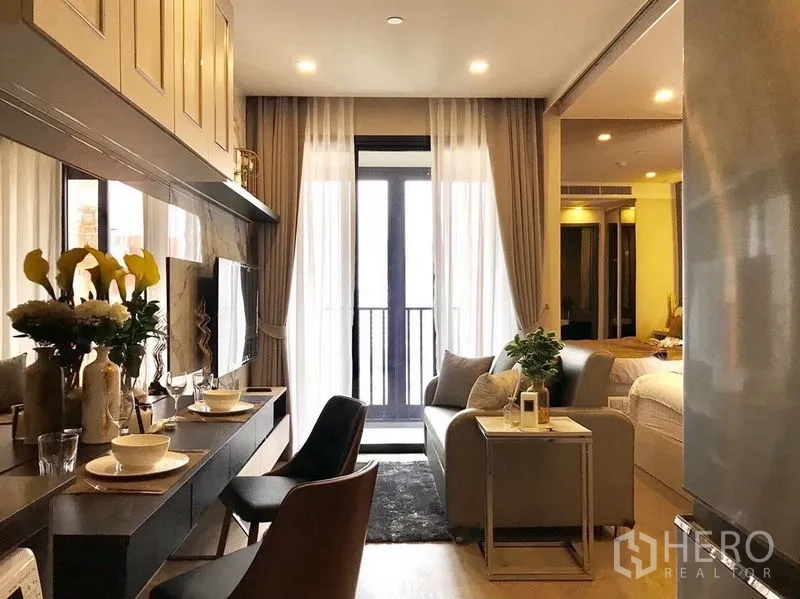 คอนโด ให้เช่าในWatthana, Bangkok - ห้องนั่งเล่นกะทัดรัดหันสู่ระเบียง ผ้าม่านโปร่ง และเคาน์เตอร์ทานอาหารดีไซน์เรียบ