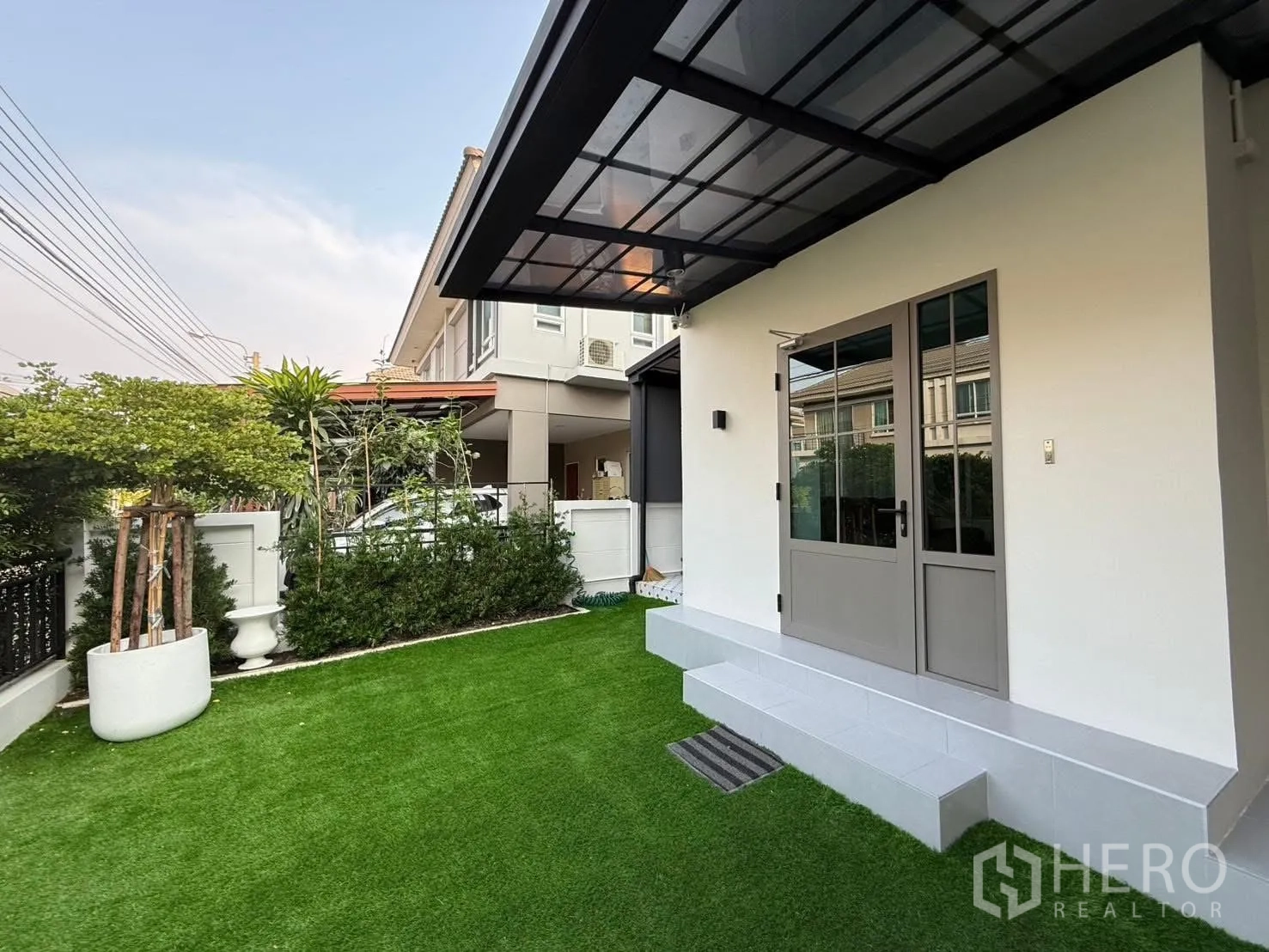 独栋房屋 for rent in Prawet, Bangkok - 前院人工草坪，带顶露台与玻璃门
