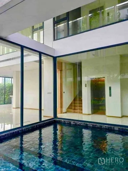 独立式住宅 出售在Huai Khwang, Bangkok - 玻璃围合的庭院私家泳池，临近楼梯间。